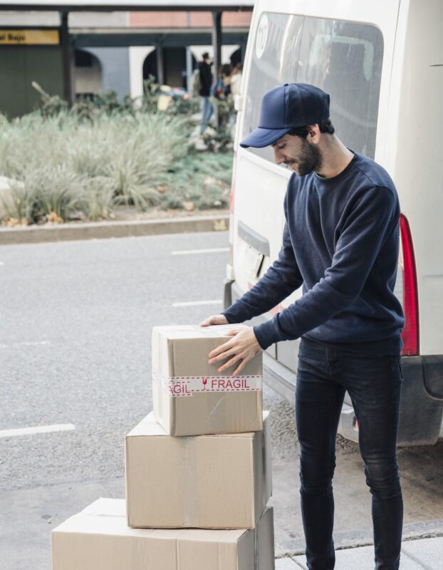 deliver-man-looking-stacked-cardboard-boxes